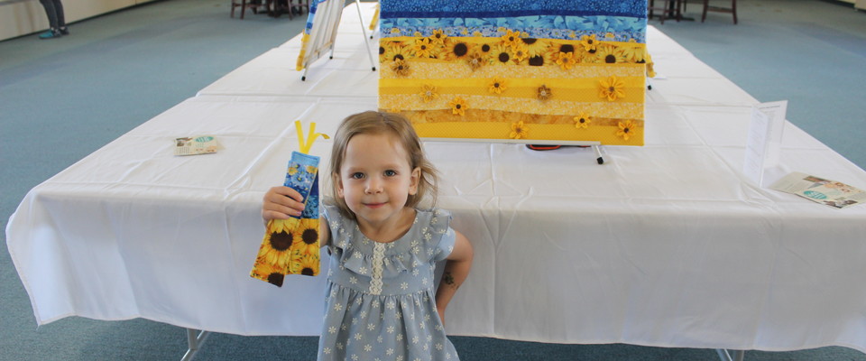 Child with hand-sewn bookmarks supporting Ukraine